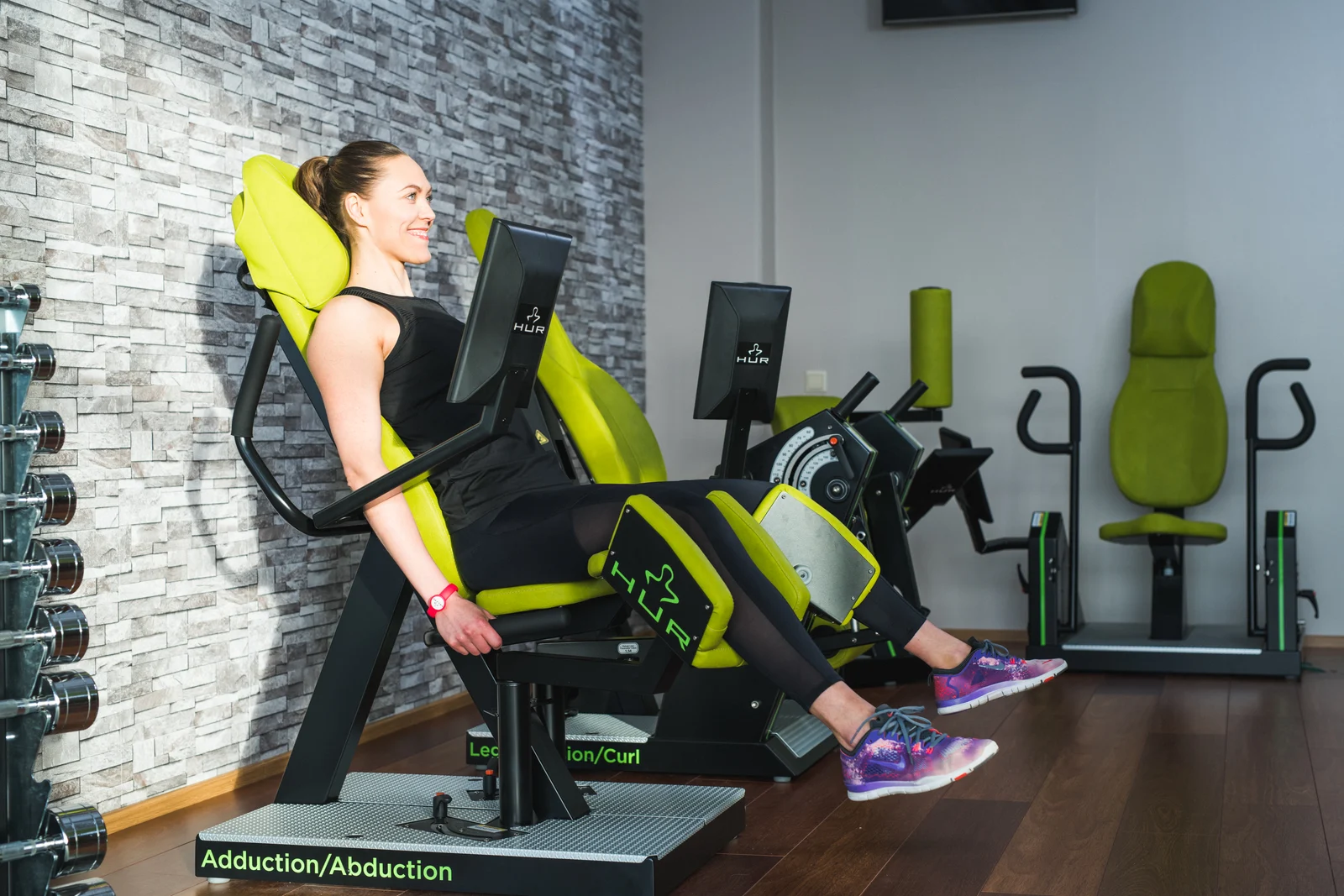 An adult exercising on a HUR machine in a strength studio